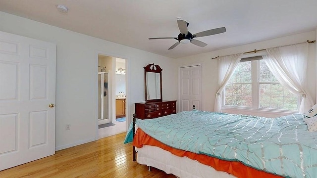 bedroom featuring ensuite bathroom, light wood-type flooring, baseboards, and ceiling fan