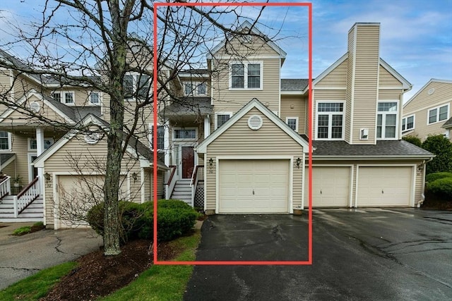 townhome / multi-family property featuring driveway and a chimney
