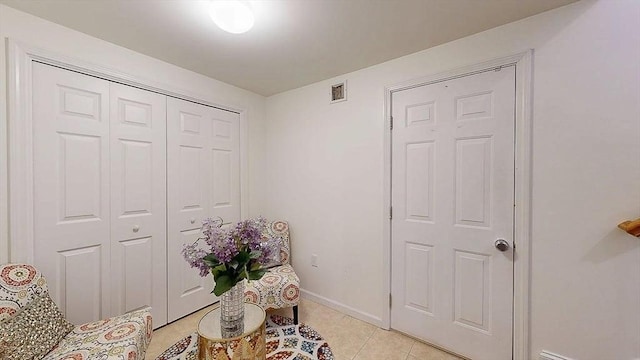 living area with light tile patterned floors, baseboards, and visible vents