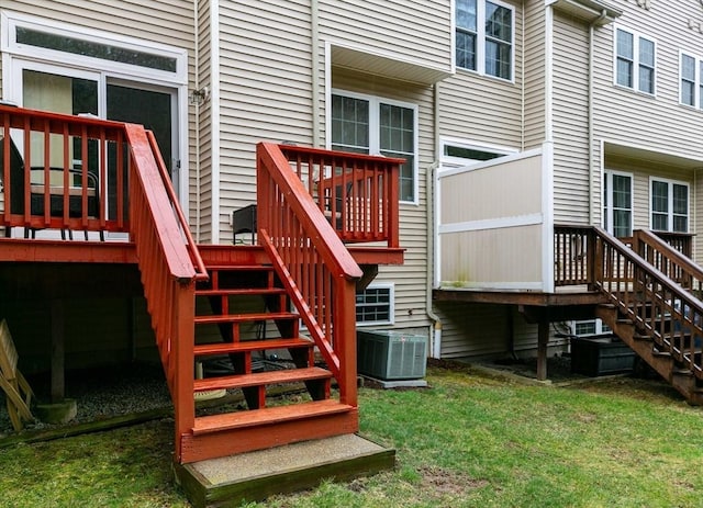 entrance to property featuring central AC unit, a wooden deck, and a yard