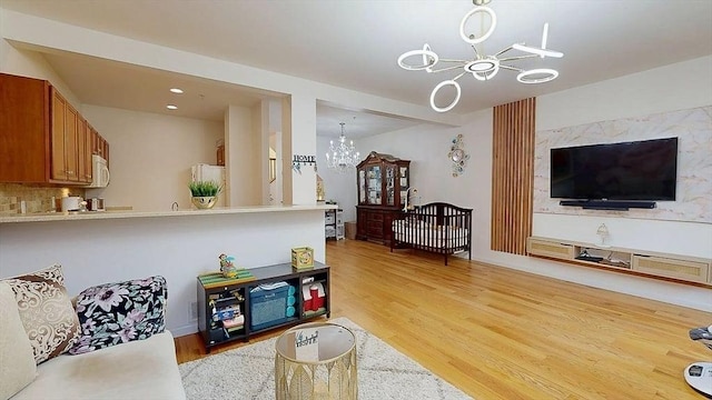 living area featuring light wood finished floors and a notable chandelier
