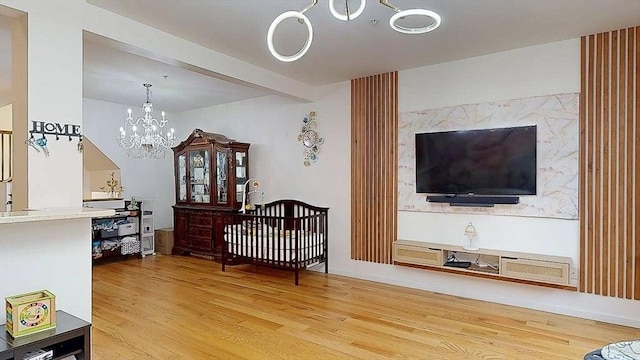 living area featuring a notable chandelier, beam ceiling, and wood finished floors