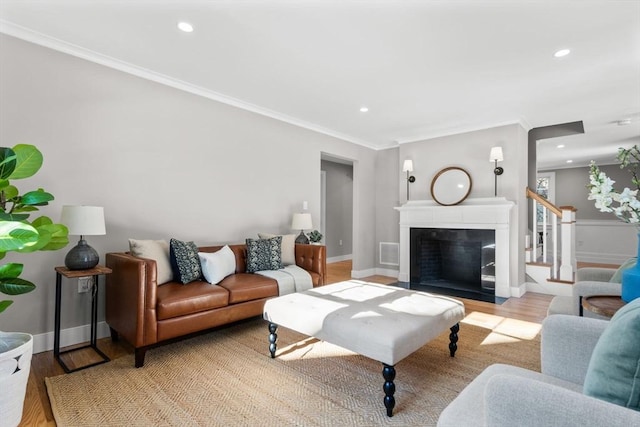 living room with ornamental molding and light hardwood / wood-style floors