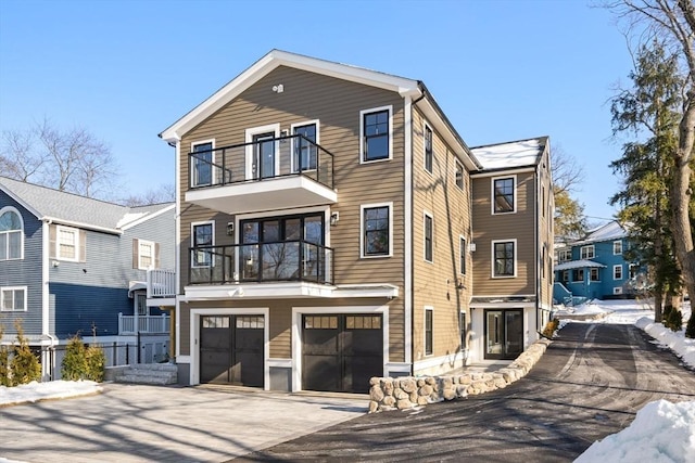 view of front of property featuring a garage and a balcony