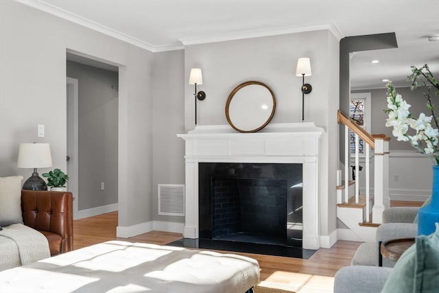 living room with light hardwood / wood-style flooring and ornamental molding