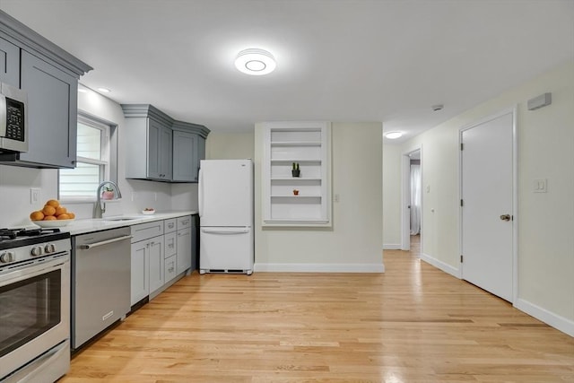 10-12 Spring Rd, Arlington, MA 02476 - kitchen featuring appliances with stainless steel finishes, light wood finished floors, open shelves, light countertops, and gray cabinetry