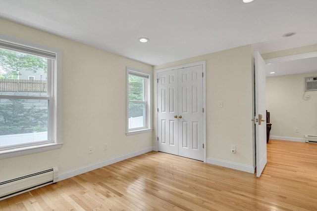 10-12 Spring Rd, Arlington, MA 02476 - unfurnished bedroom with baseboard heating, multiple windows, light wood finished floors, recessed lighting, and a baseboard heating unit