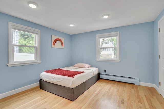 10-12 Spring Rd, Arlington, MA 02476 - bedroom featuring a baseboard heating unit, multiple windows, and wood finished floors