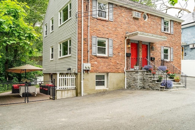 10-12 Spring Rd, Arlington, MA 02476 - view of front of house featuring brick siding, an AC wall unit, and a gate