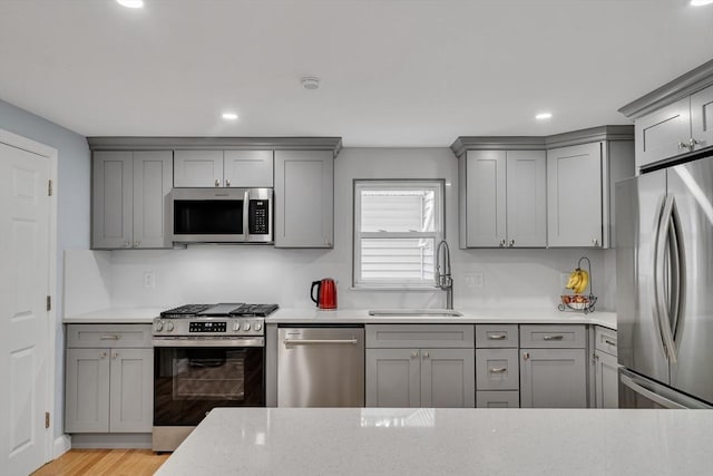 10-12 Spring Rd, Arlington, MA 02476 - kitchen with appliances with stainless steel finishes, gray cabinetry, recessed lighting, light wood-type flooring, and light stone countertops