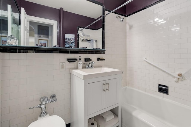 full bathroom featuring vanity, backsplash, tiled shower / bath combo, toilet, and tile walls