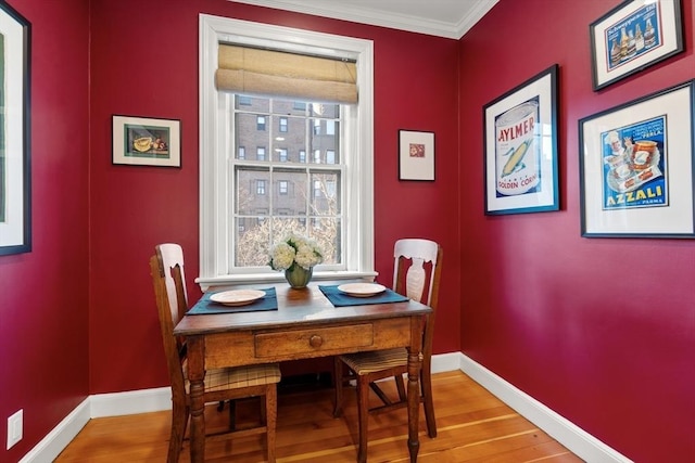 dining area featuring light hardwood / wood-style flooring and ornamental molding