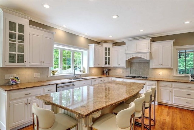 19 Mulberry Ln, Franklin, MA 02038 - kitchen with a sink, a breakfast bar, appliances with stainless steel finishes, light stone counters, and ornamental molding