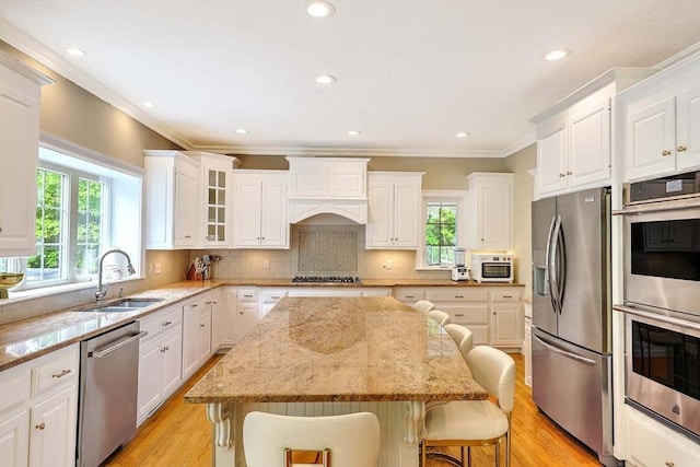 19 Mulberry Ln, Franklin, MA 02038 - kitchen with appliances with stainless steel finishes, a sink, a kitchen breakfast bar, plenty of natural light, and ornamental molding