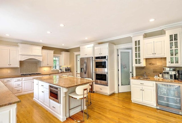 19 Mulberry Ln, Franklin, MA 02038 - kitchen featuring beverage cooler, appliances with stainless steel finishes, ornamental molding, white cabinets, and tasteful backsplash
