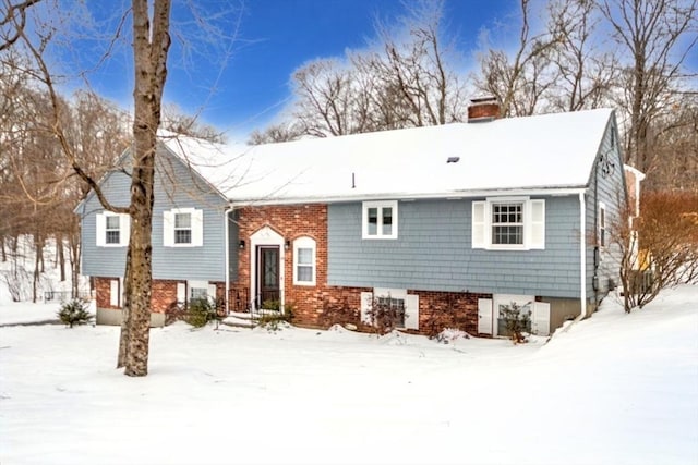 split foyer home featuring a chimney and brick siding