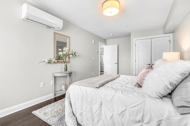 bedroom with dark wood-type flooring, an AC wall unit, and a closet