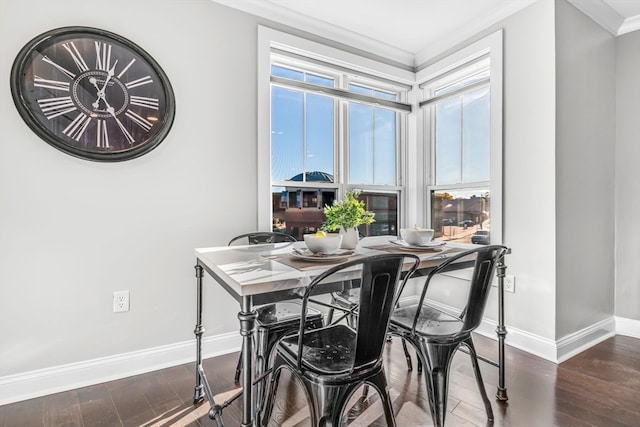 dining area with dark wood-type flooring and crown molding