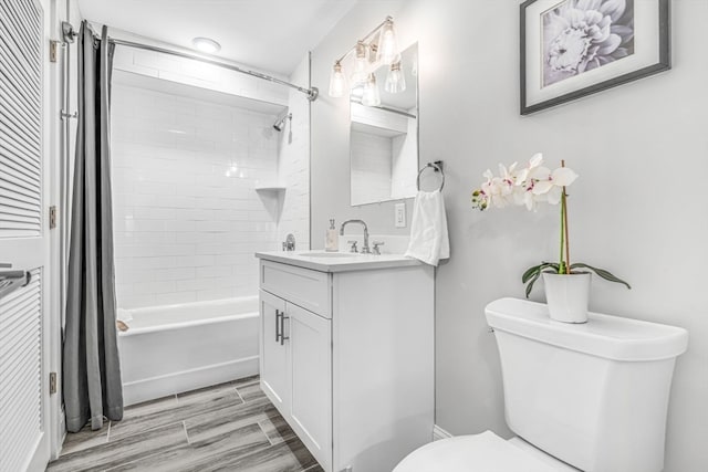 full bathroom with toilet, hardwood / wood-style flooring, vanity, and shower / tub combo