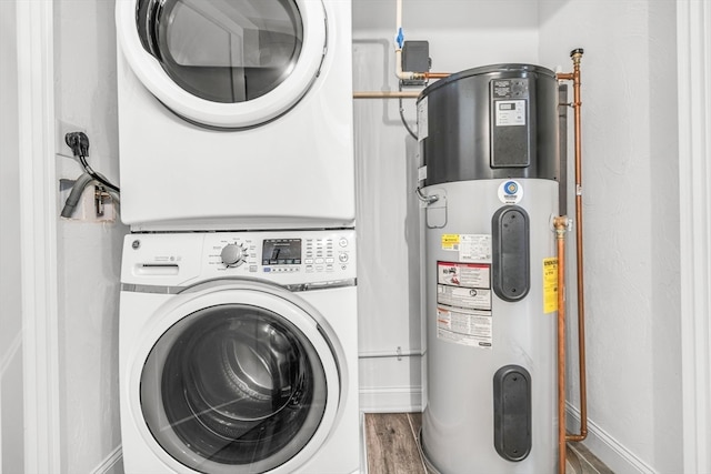 laundry room featuring stacked washing maching and dryer, wood-type flooring, and heat pump water heater