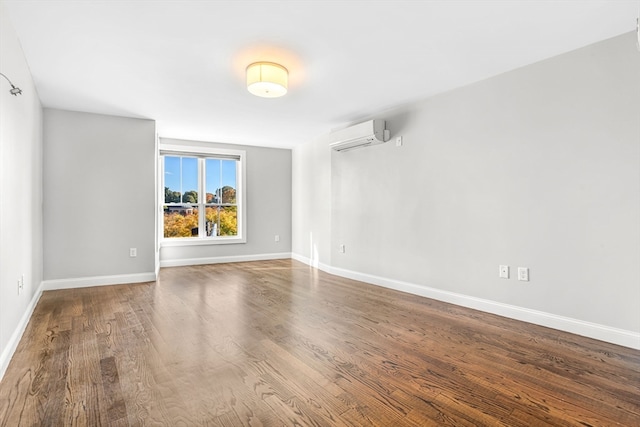 unfurnished room featuring a wall mounted air conditioner and hardwood / wood-style floors