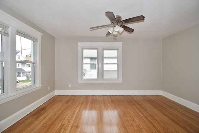 unfurnished room with healthy amount of natural light, light wood-style flooring, and baseboards