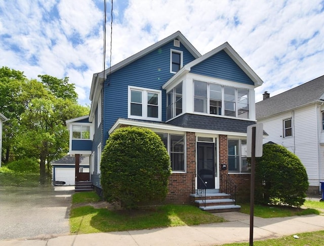 view of front of home featuring brick siding, entry steps, and a detached garage