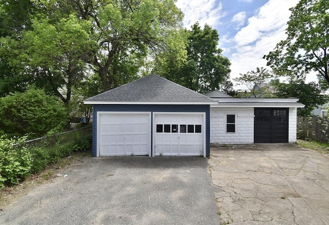 detached garage featuring fence