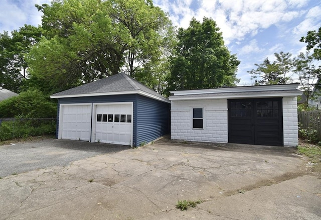 detached garage featuring fence