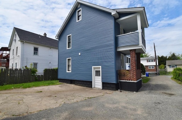 view of side of property with a balcony and fence