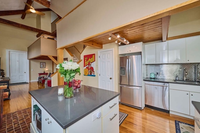 kitchen featuring tasteful backsplash, white cabinetry, appliances with stainless steel finishes, sink, and light hardwood / wood-style flooring