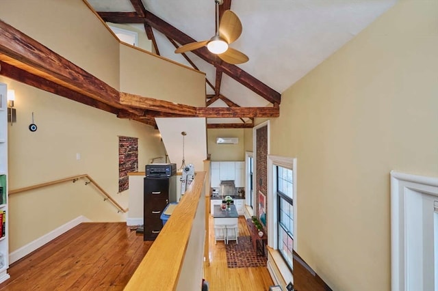 interior space featuring hardwood / wood-style floors, beam ceiling, and high vaulted ceiling