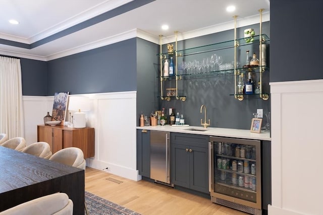 bar featuring beverage cooler, a wainscoted wall, high quality fridge, a sink, and indoor wet bar