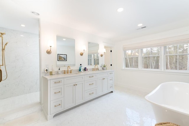 bathroom with double vanity, a marble finish shower, visible vents, and a sink