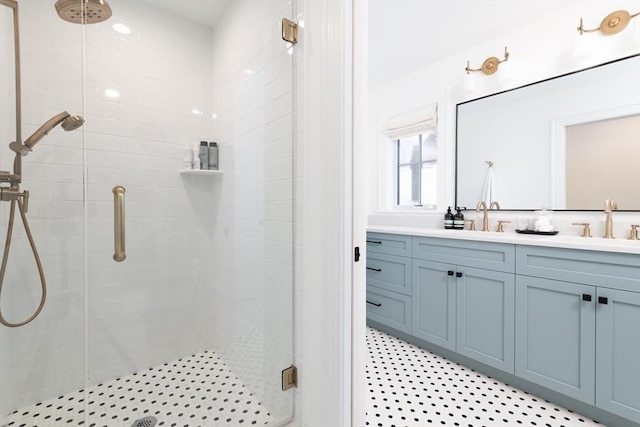 bathroom featuring a sink, a shower stall, and double vanity