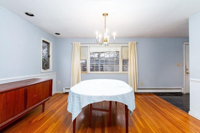 dining room featuring baseboard heating, dark hardwood / wood-style flooring, and a chandelier