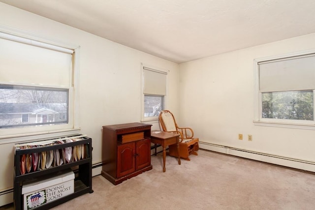 sitting room with a baseboard radiator and light colored carpet