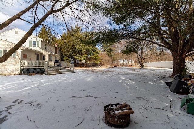 yard covered in snow with an outdoor fire pit and a deck