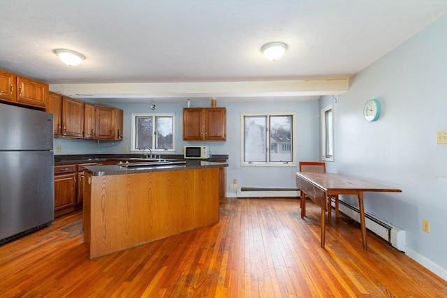 kitchen with a baseboard heating unit, stainless steel fridge, hardwood / wood-style floors, and a kitchen island