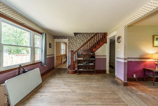 164 Leonard St, Agawam, MA 01001 - living room with wallpapered walls, baseboards, wood finished floors, stairs, and radiator