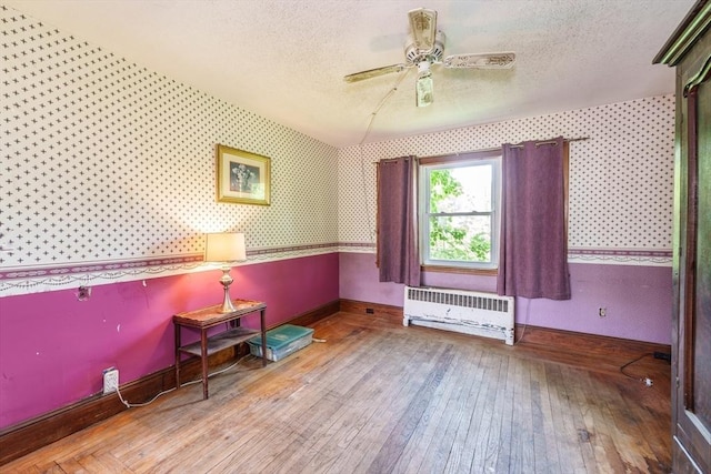 164 Leonard St, Agawam, MA 01001 - living area featuring radiator, wood-type flooring, baseboards, ceiling fan, and wallpapered walls