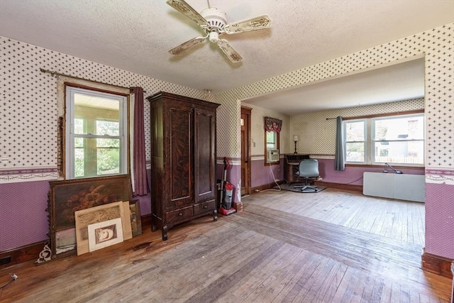 164 Leonard St, Agawam, MA 01001 - interior space with wallpapered walls, wood-type flooring, a textured ceiling, a ceiling fan, and baseboards
