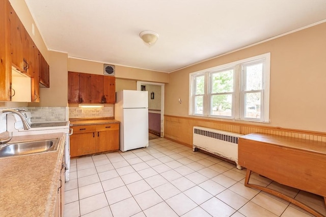 164 Leonard St, Agawam, MA 01001 - kitchen featuring freestanding refrigerator, radiator heating unit, brown cabinets, crown molding, and light countertops