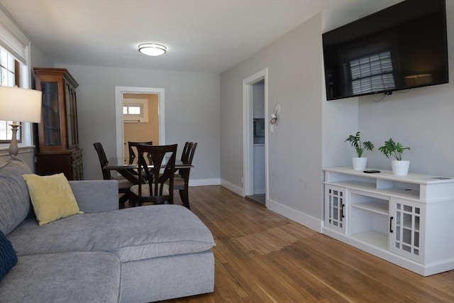 living room with plenty of natural light and dark wood-type flooring