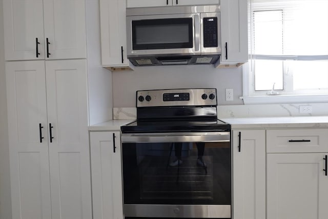 kitchen featuring stainless steel appliances and white cabinets