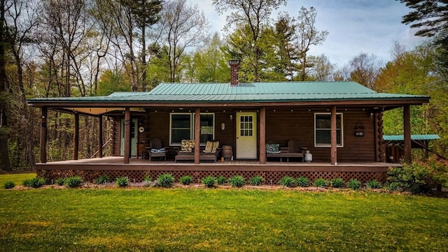 rear view of property with a yard and an outdoor hangout area