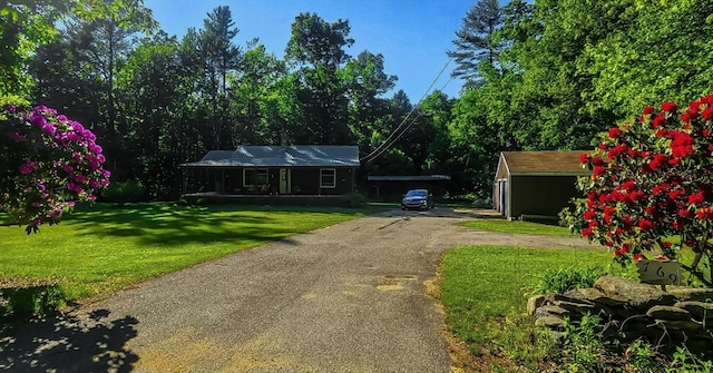 ranch-style home with a front yard and a storage unit