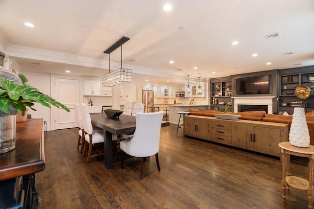 dining room with recessed lighting, dark wood-style floors, ornamental molding, and a fireplace