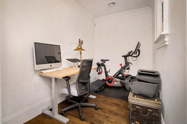 office space with visible vents, crown molding, baseboards, and wood finished floors