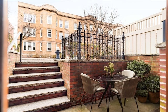 view of patio with outdoor dining space and fence